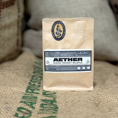 Aether Dark Roast bag standing on a burlap coffee sack at the Spiritus roastery