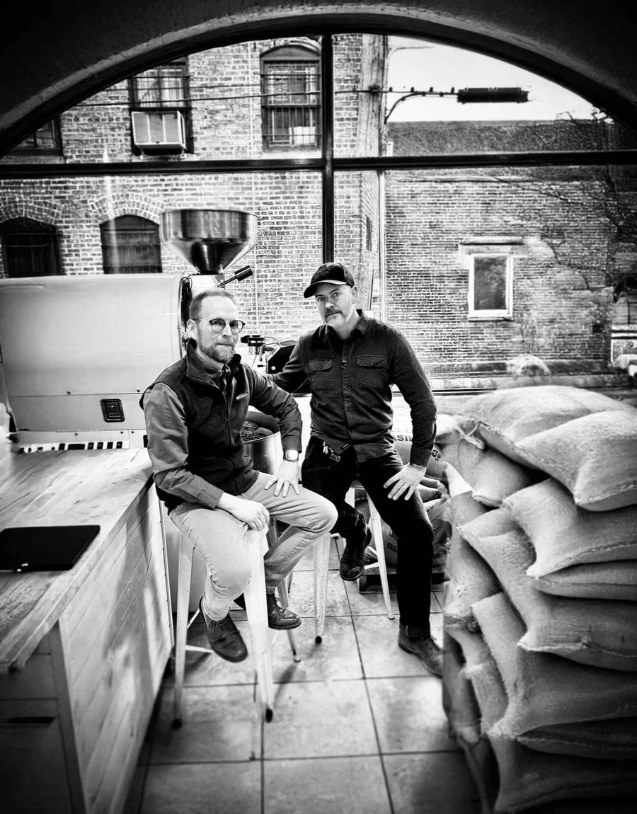 Jason and Nick, the Spiritus founders, beside the roaster and sacks of green coffee